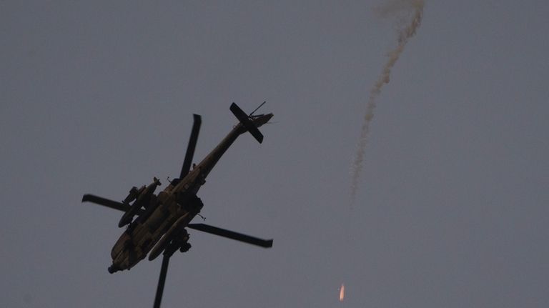 An Israeli helicopter releases flares as it flies over Israeli-Gaza...