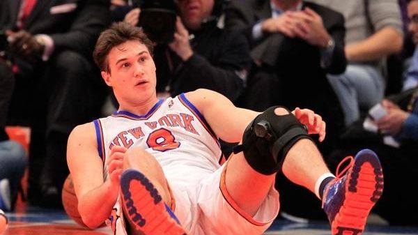 Danilo Gallinari of the New York Knicks falls to the...