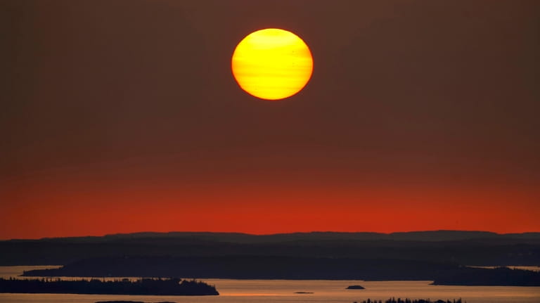 The sun rises over Maine's Penobscot Bay, Wednesday, Sept. 27,...