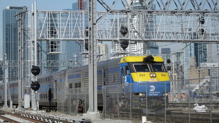 A Long Island Rail Road train passes under a new...