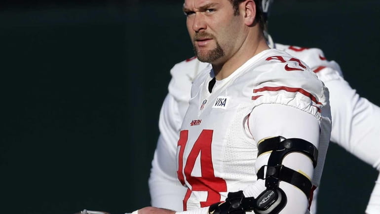 San Francisco 49ers defensive tackle Justin Smith wears a brace...