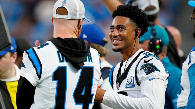 Carolina Panthers quarterbacks Andy Dalton (14) and Bryce Young watch...