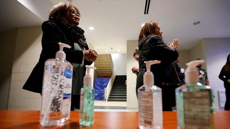 Campaign rallygoers use hand sanitizer Monday in Detroit amid concern...