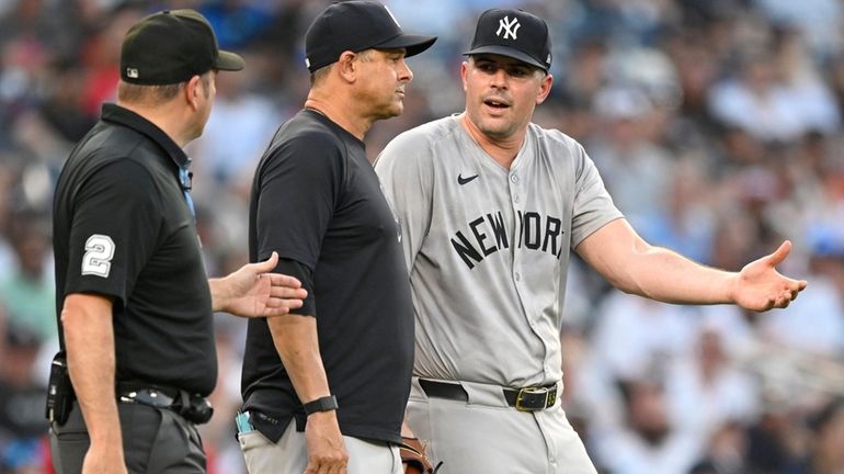 Yankees pitcher Carlos Rodón, right, argues with second base umpire...