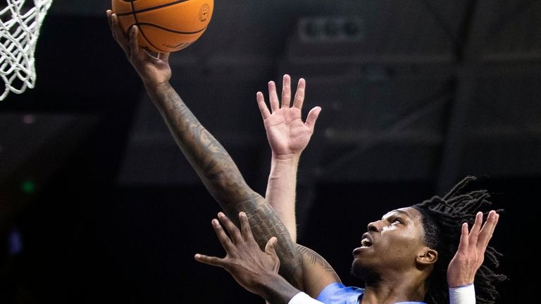 North Carolina's Caleb Love (2) drives to the basket as...