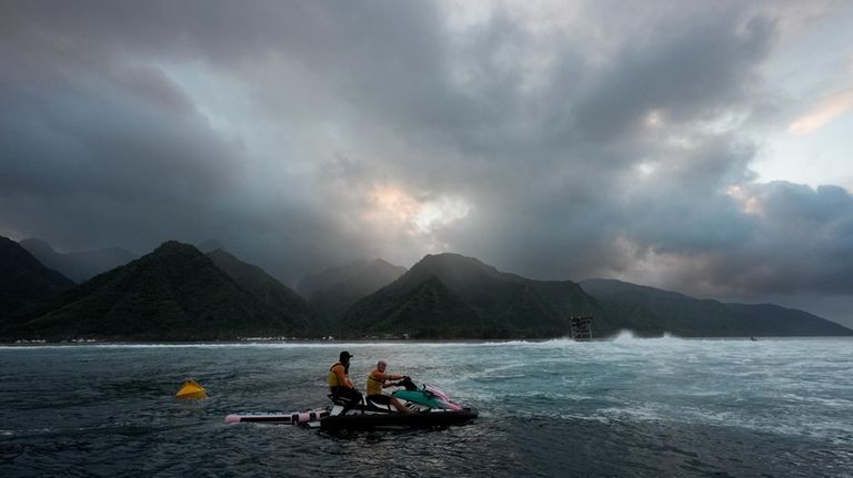 Members of the water safety team look on from a...