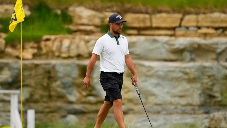 Xander Schauffele lines up a putt on the 13th hole...