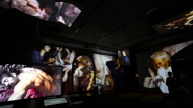 People watch the Rubens Experience audiovisual display in the reception...