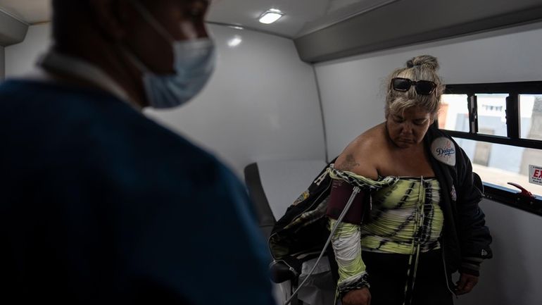 Norma Terrazas, right, gets her blood pressure checked by medical...