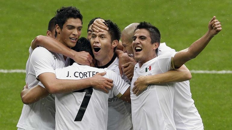 Mexico's Javier Cortes (7) is hugged by his teammates after...