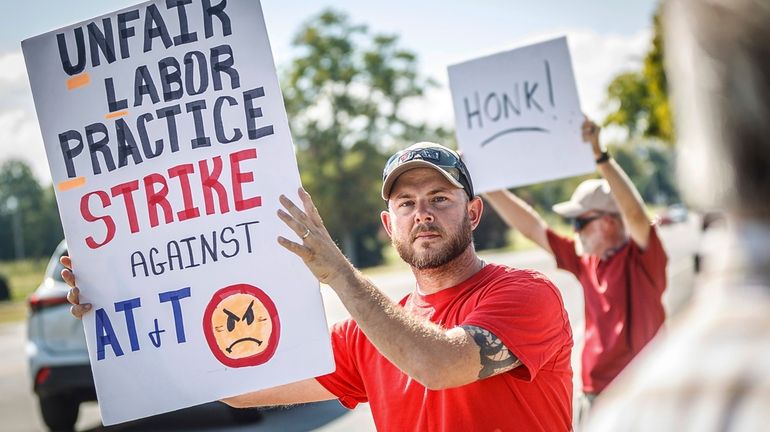 Drew Thigpen, left, and Robert Rogers join other AT&T workers...