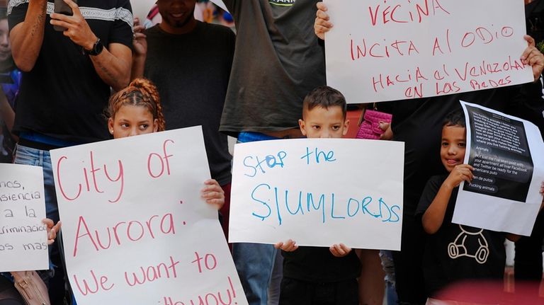 Residents hold up placards during a rally staged by the...