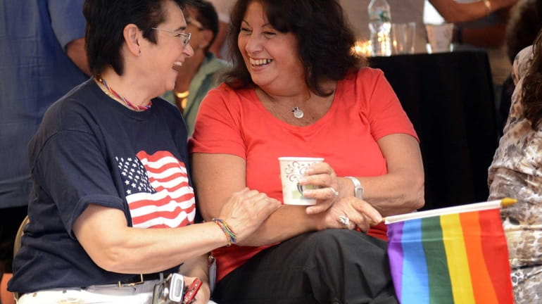 Eveline Marcello, left and Margie Luciano, right, share a laugh...