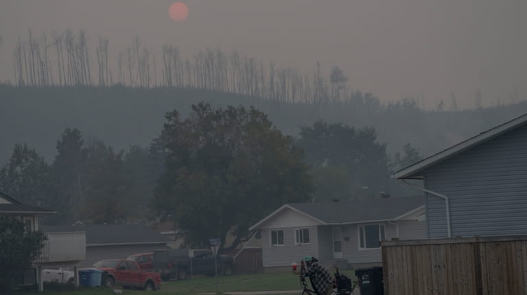 A person rides a bicycle on a smokey day due...