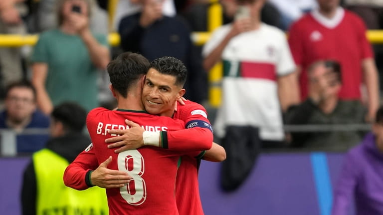 Portugal's Bruno Fernandes celebrates with Portugal's Cristiano Ronaldo after scoring...