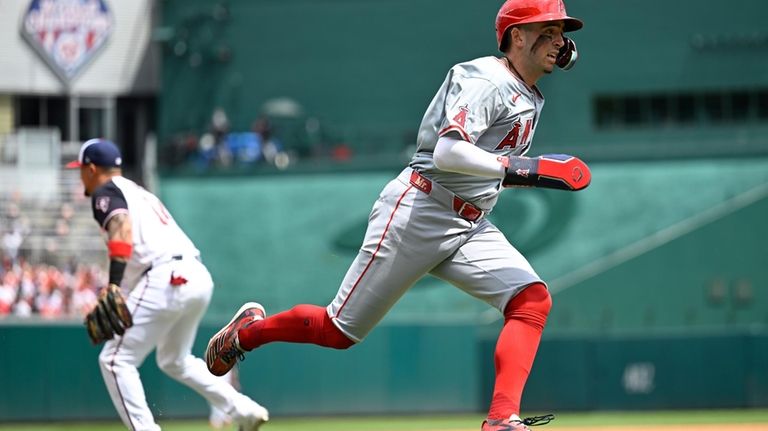 Los Angeles Angels' Zach Neto, right, heads home for a...