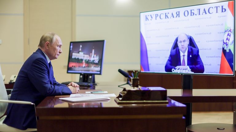 Russian President Vladimir Putin, left, listens to acting Governor of...