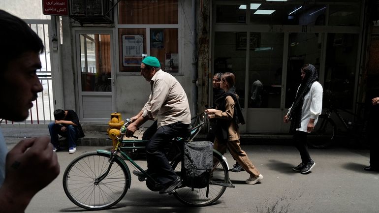 People make their way through the old main bazaar of...