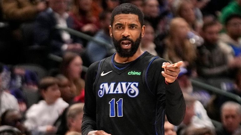 Dallas Mavericks guard Kyrie Irving celebrates after sinking a basket...