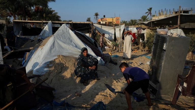 Palestinians look at the destruction after an Israeli airstrike on...