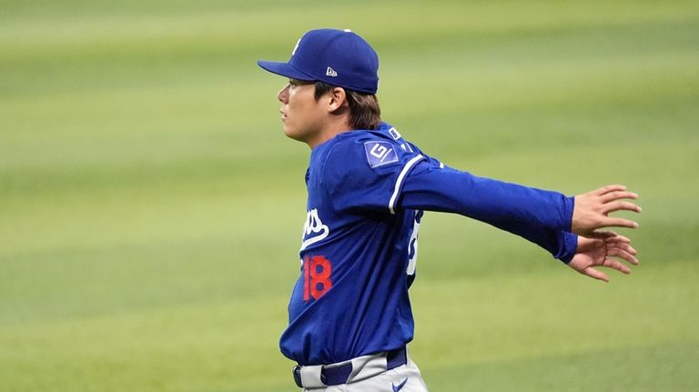 Injured Los Angeles Dodgers starting pitcher Yoshinobu Yamamoto, of Japan,...