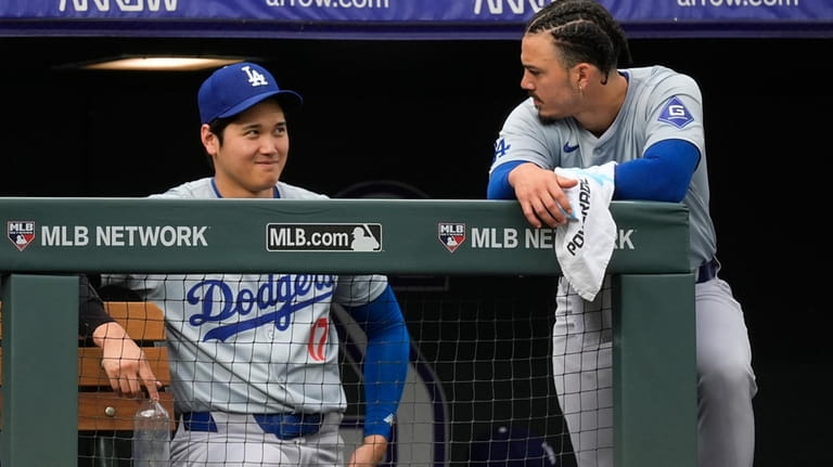 Los Angeles Dodgers' Shohei Ohtani, left, chats with Miguel Vargas...