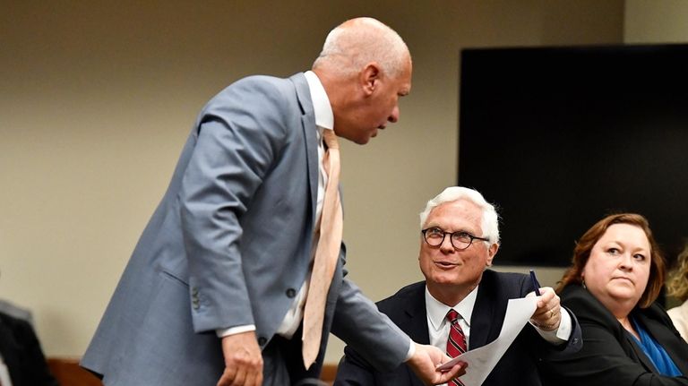 Jefferson County Attorney Mike O'Connell, right, hands a document to...