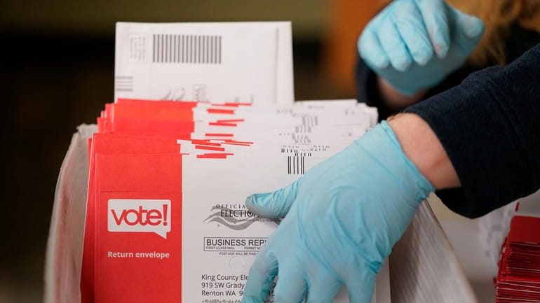 Erik Thurston prepares ballots from a drop box for the...