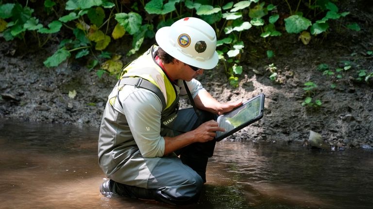 A Environmental Protection Agency worker works in Leslie Run in...