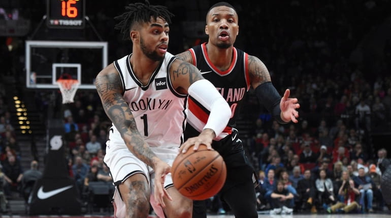 Nets guard D'Angelo Russell passes the ball in front of...