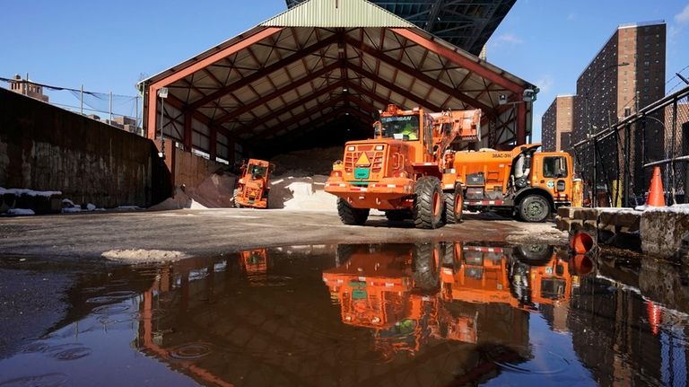 FILE — New York City Sanitation Department workers use a...