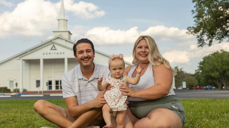 Sam Earle, left, and his wife, Tori, pose with their...