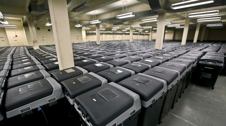 Rows and rows of electronic voting machines are stored in...