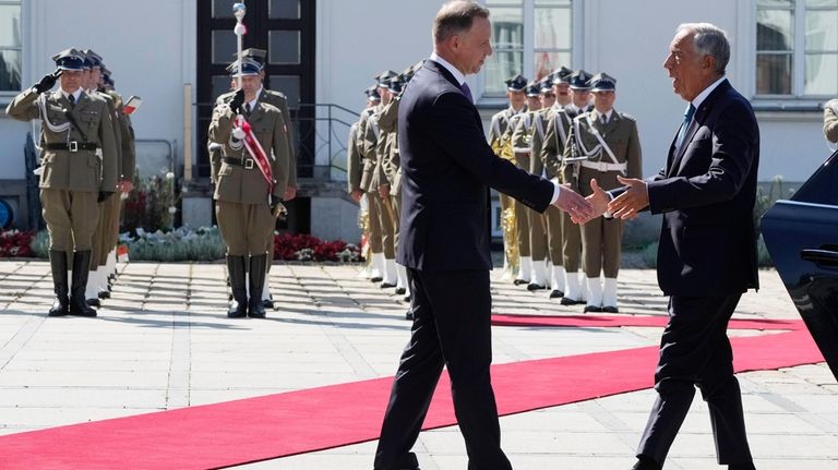 Poland's President Andrzej Duda, left, greets Portuguese President Marcelo Rebelo...