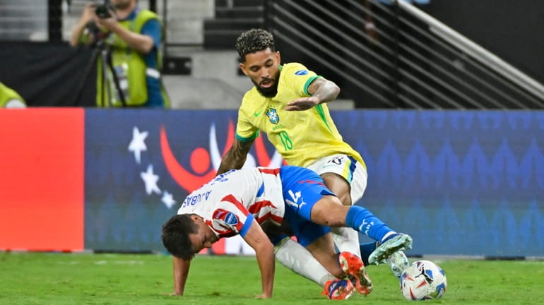 Brazil's Douglas Luiz and Paraguay's Adrian Cubas battle for the...