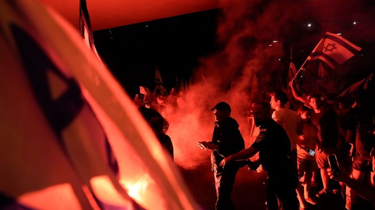 People block a road as they protest calling for a...