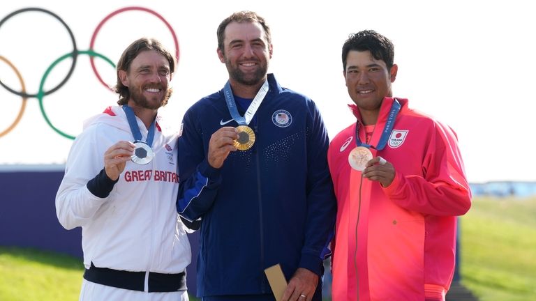 Gold medalist Scottie Scheffler, of the United States, centre, with...