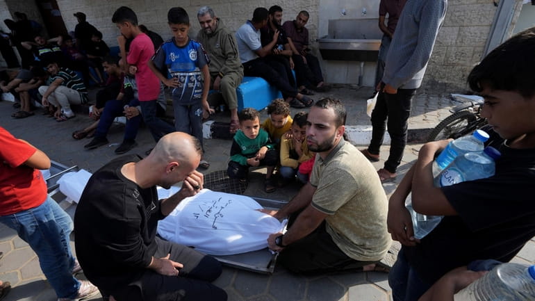Palestinians mourn over the body of their father, Mohsem al...