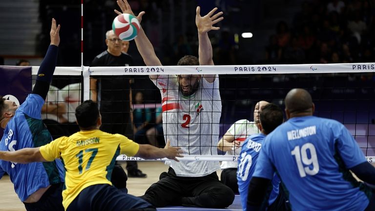 Iran's Morteza Mehrzadselakjani blocks the ball during the preliminary sitting...