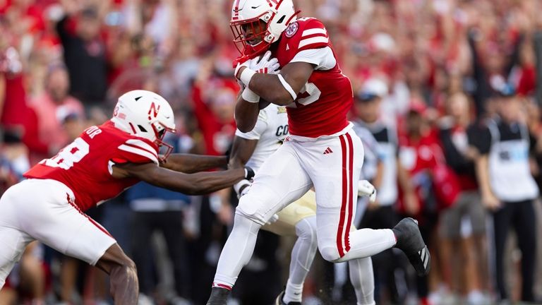 Nebraska running back Dante Dowdell, front, runs in a touchdown...