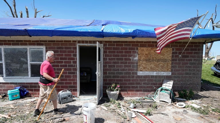 Bill Yount walks into his tornado damaged home, Thursday, May...