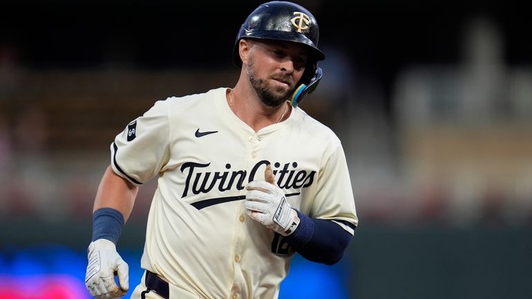 Minnesota Twins' Kyle Farmer runs the bases after hitting a...