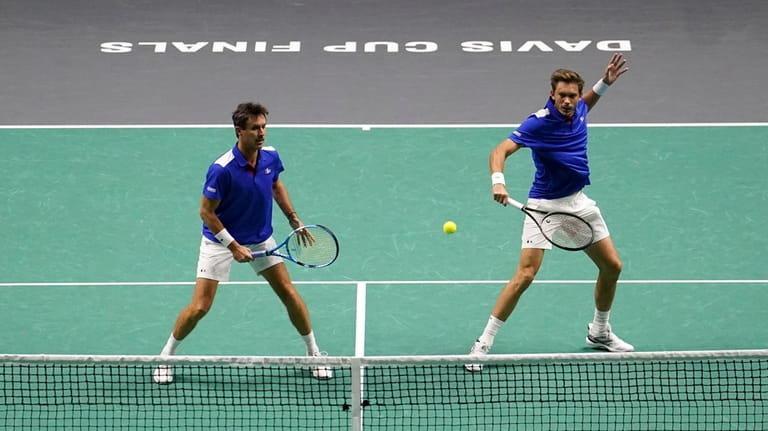 France's Edouard Roger-Vasselin, left, and Nicolas Mahut in action against...