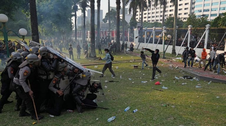 Protesters clash with security officers as they attempt to storm...