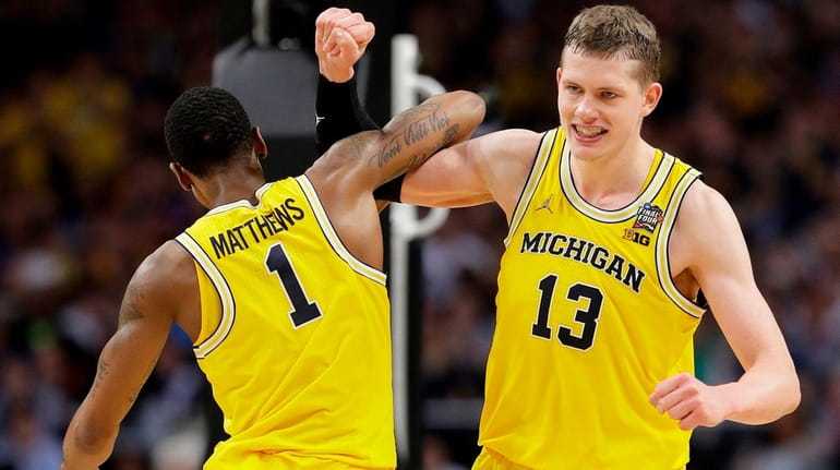 Michigan's Moritz Wagner celebrates with Charles Matthews during the second...