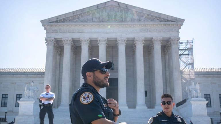 Supreme Court Police officers stand on duty outside of the...