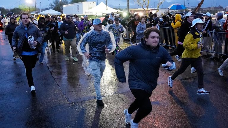 Fans run onto the course prior to the continuation of...