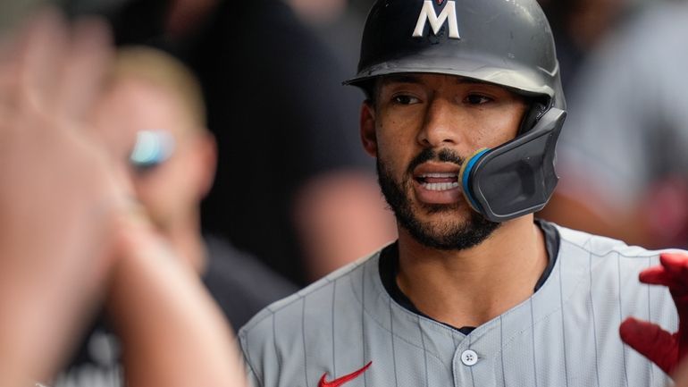 Minnesota Twins' Carlos Correa celebrates in the dugout after hitting...