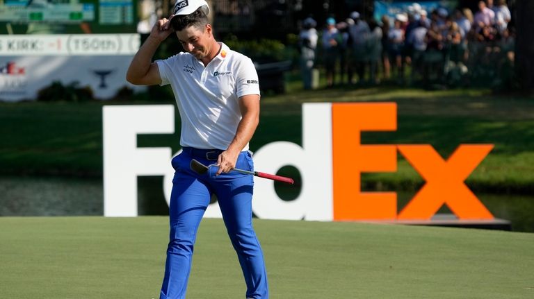 Viktor Hovland, of Norway, walks off the 18th green after...