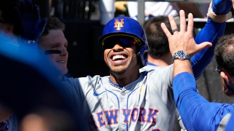 Mets' Francisco Lindor celebrates with teammates after hitting a solo...